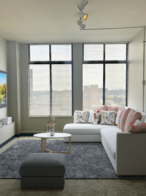 a living room with a white couch and a table at Delmar Loop Apartments, Missouri, 63112
